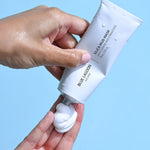 Model dispensing Silica Mud Mask into hand from tube