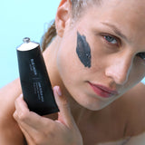 Model with Lava Scrub Mask applied to cheek holding tube
