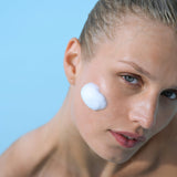 Model applying Foaming Cleanser foam to cheek