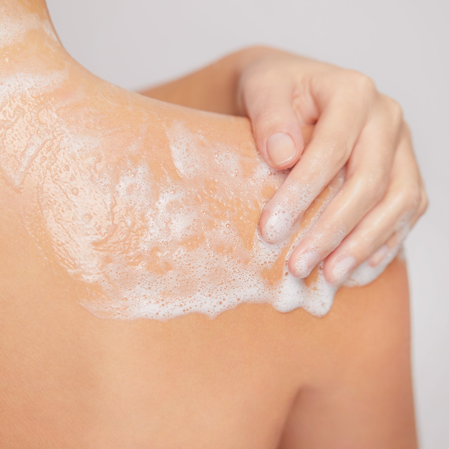 Model applying foamy Shower Gel to shoulder during cleansing